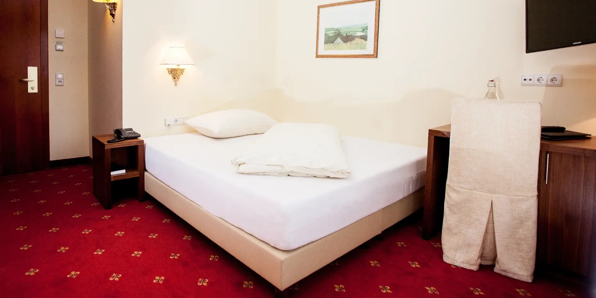 Einzelzimmer Deluxe – Bett und Schreibtisch