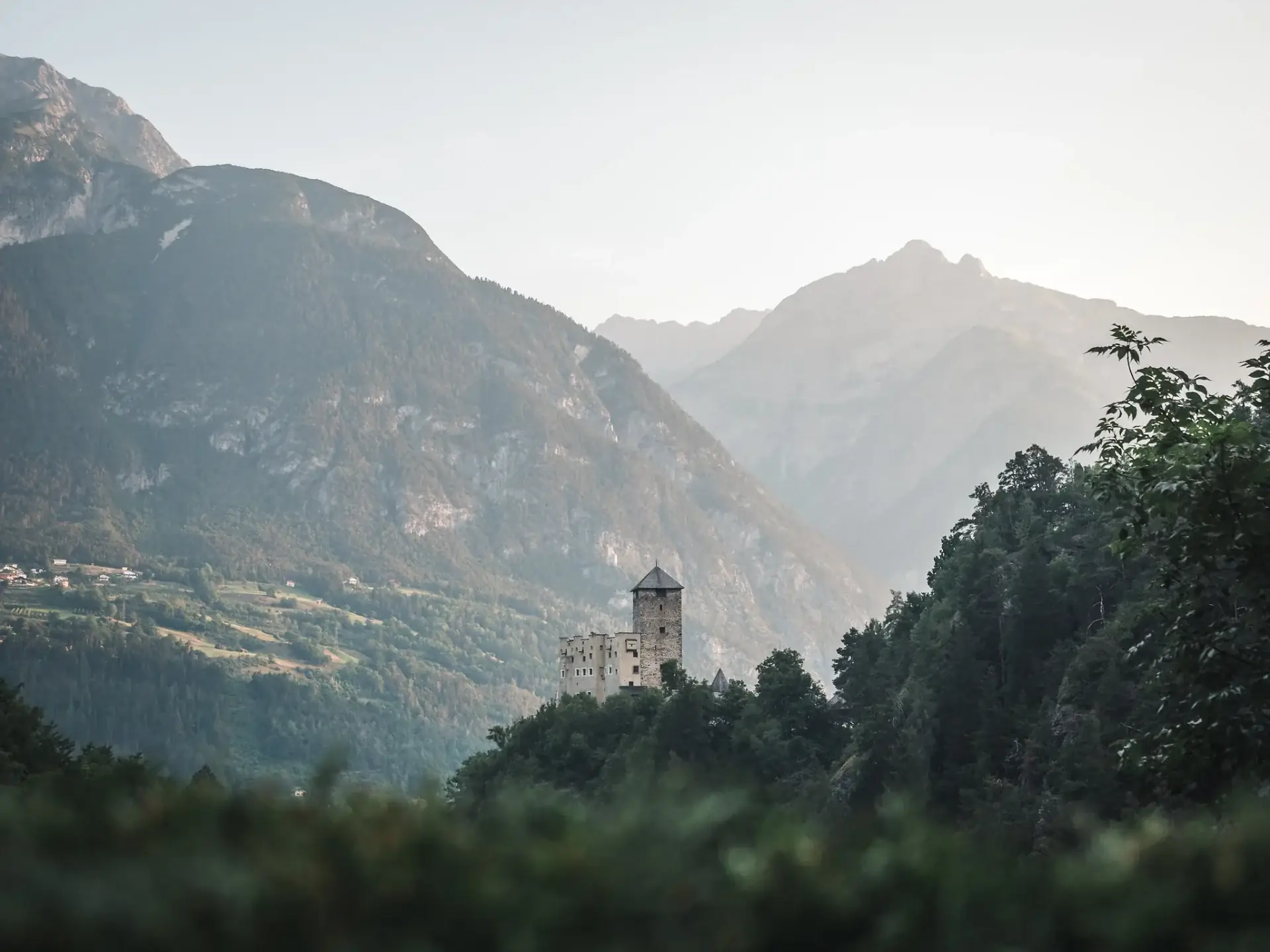 Landeck Castle in the woods, with the Tyrolean mountains in the background