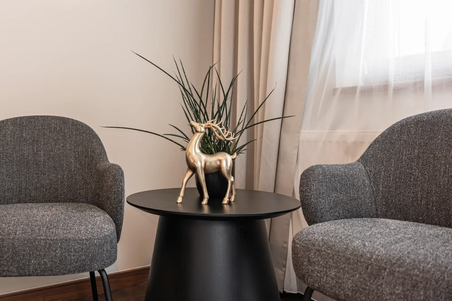 Doppelzimmer Gramaser – Sitzecke mit goldenem Hirsch